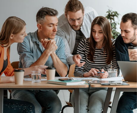 Personas del equipo trabajando juntas alrededor de una mesa